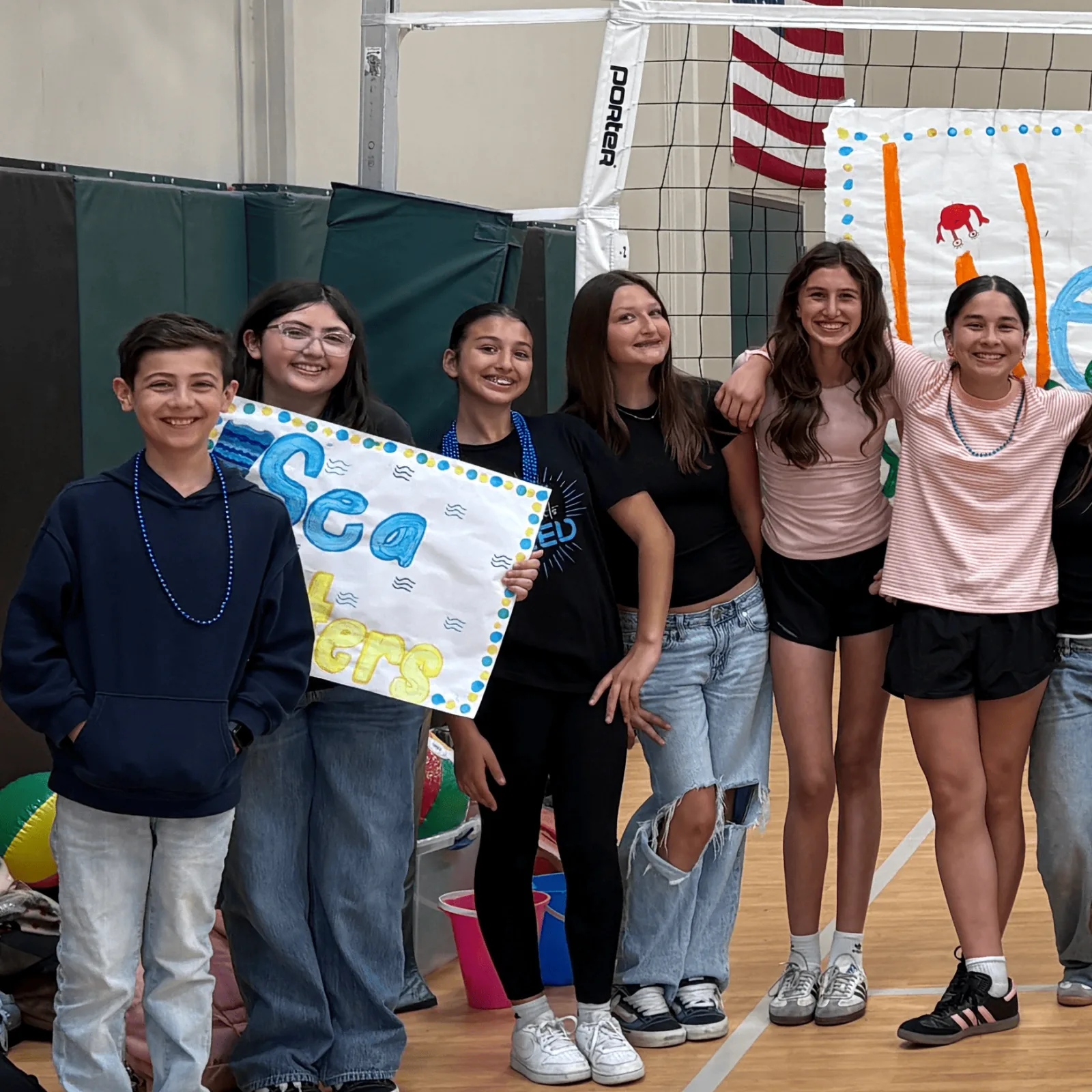 A SLED student team with their project sign